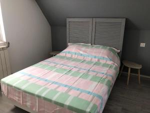 a bedroom with a bed with a striped comforter at Maison individuelle avec Jardinet in Arques-la-Bataille +4 photos