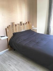 a bed in a room with a wooden head board at Maison individuelle avec Jardinet in Arques-la-Bataille
