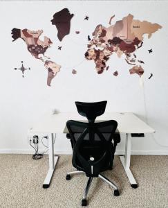 a chair in front of a desk with a world map on a wall at Nice place surrounded by the water in Emeryville +7 photos