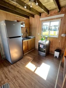 a kitchen with a stainless steel refrigerator and a stove at Santo Descanso in Punta Del Diablo