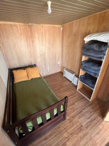 a small room with a bed in a tiny house at Santo Descanso in Punta Del Diablo