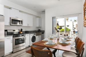a kitchen with a wooden table with chairs and a dining room at Enjoy Stylish 4BR Townhouse Sleeps 8 with Wi-Fi in Los Angeles