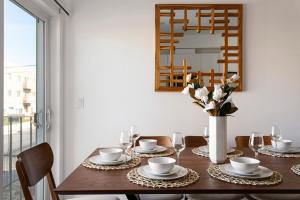 a dining room table with a vase of flowers and a mirror at Enjoy Stylish 4BR Townhouse Sleeps 8 with Wi-Fi in Los Angeles +37 photos