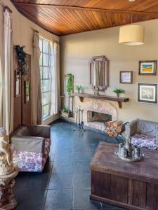 a living room with a couch and a fireplace at Hotel Santiago in Lindóia