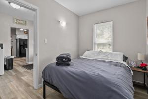 a bedroom with a bed with a gray blanket at Central Oshkosh Stay - Walk to Lake and Downtown in Oshkosh