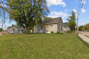 a house on a street with a green yard at Central Oshkosh Stay - Walk to Lake and Downtown in Oshkosh