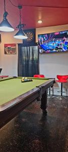 a room with a pool table and a tv at Galloway's Cottage in Saint Johnʼs