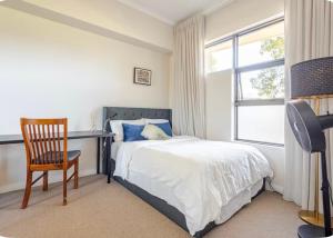 a bedroom with a bed and a desk and a chair at Upscale neighbourhood guest quarters in Perth
