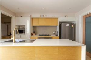 a kitchen with white cabinets and a stainless steel refrigerator at Upscale neighbourhood guest quarters in Perth
