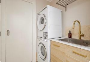 a kitchen with a washing machine and a sink at Upscale Neighbourhood Guest Quarters in Perth +2 photos