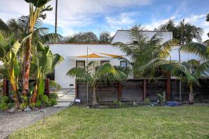 una casa blanca con palmeras delante en West Beach Villa 3, en Santa Bárbara