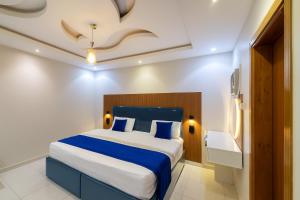 a bedroom with a large bed with blue and white sheets at شوران الأولى in Al Madinah