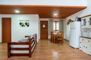 a kitchen and dining room with a table and a refrigerator at BC Praia Estaleiro - 2 Vagas, Ar, Churras e Pet OK in Balneário Camboriú