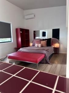 a bedroom with a bed and a red ottoman at Aurora Self Contained Studio in Brisbane