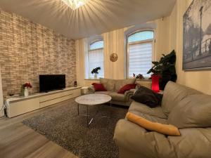 a living room with a couch and a tv at Seestadt Apartment in ruhiger Lage Erdgeschosswohnung mit WLAN in Bremerhaven