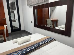 a bedroom with a bed and a large mirror at Hostal Huella in Lambayeque