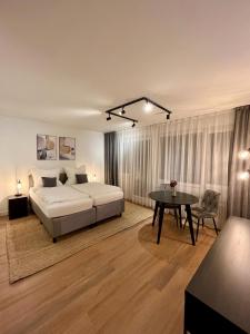 a large bedroom with a bed and a table at G&P Housing Apartments - XXL Wohnung für Familien & Gruppen 120qm mit 3 Schlafzimmern, 3 Badezimmern, Panoramabalkon und großer Küche in Altensteig