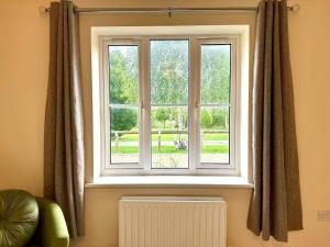 a window in a living room with a radiator at Charming 3 bedroomed House in Bicester sleeps 6 in Chesterton