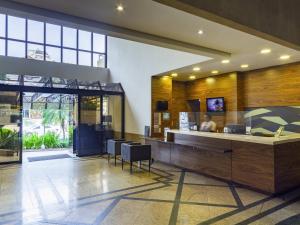 un hall avec un comptoir et des chaises dans un bâtiment dans l'établissement Mercure Curitiba Golden, à Curitiba 132 autres photos