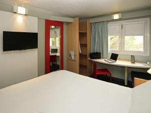 Una televisión o centro de entretenimiento en ibis Nîmes Ouest - A9