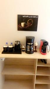 - une étagère avec une cafetière et des tasses dans l'établissement Luxury apartment with outdoor seating, separate entrance and self check-in, à Khamis Mushait