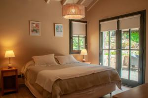 a bedroom with a large bed and two windows at Las Cumbres Apart & Suites in San Martín de los Andes