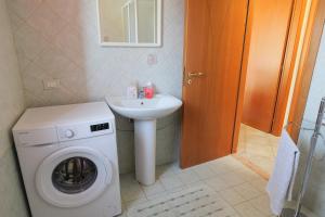 a bathroom with a washing machine and a sink at Villetta indipendente a due passi dal mare 