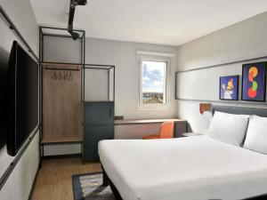 a hotel room with a bed and a window at Ibis Styles Abidjan Plateau in Abidjan