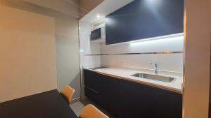 a small kitchen with a sink and a microwave at Casco Histórico Apart I in Buenos Aires +34 photos