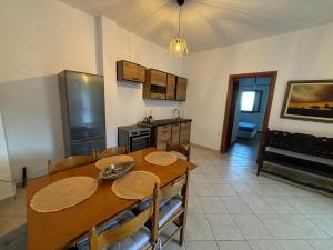 - une cuisine avec une table et des chaises en bois dans la chambre dans l'établissement Magic estate on the wave 1, à Kotronas