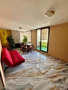 a living room with a red couch and a table at Hotel paipa travel in Paipa