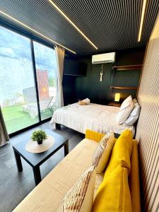 a room with two beds and a couch and a table at TinyHouse OASIS con Jacuzzi&Cenote&Piscina in Telchac Puerto