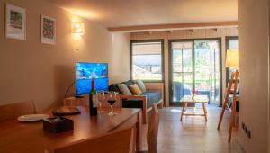 a living room with a couch and a table with wine glasses at Las Cumbres Apart & Suites in San Martín de los Andes