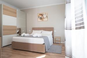 a white bedroom with a bed and a window at Abano Terme-Luxury Suites, 4 ospiti-free parking in Abano Terme