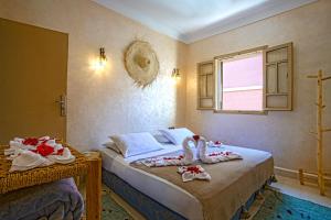 Un dormitorio con dos camas con toallas encima. en Riad El Kennaria, en Marrakech