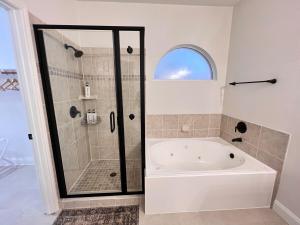 a white bath tub in a bathroom with a shower at Spacious Roanoke Retreat in Roanoke +13 photos