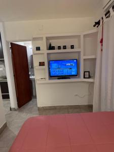 ein Wohnzimmer mit einem Flachbildfernseher an der Wand in der Unterkunft Acogedor departamento cerca de rios, montañas y naturaleza in Salta