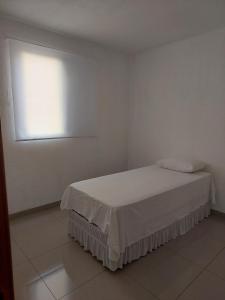 ein weißes Zimmer mit einem Bett und einem Fenster in der Unterkunft Apartamento novinho e aconchegante in Piracicaba