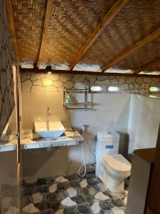a bathroom with a white toilet and a sink at Ananda Bungalow Tetebatu in Tetebatu