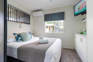 un dormitorio con una cama y una ventana en Holiday Haven Burrill Lake, en Burrill Lake 70 fotos más