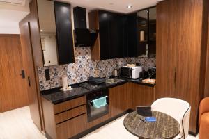 a small kitchen with a table and a microwave at Pause parfaite in El Aouina Station