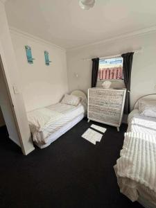 Un dormitorio con dos camas y una ventana. en Ohope Ocean Breeze Escape, en Ohope Beach
