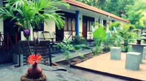 a vase sitting on a table in front of a house at Surf Dine in Matara
