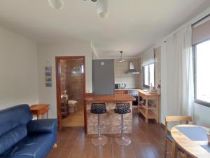 a living room with a blue couch and a kitchen at Casa Los Artesanos in Santa Cruz de Tenerife