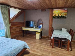 a bedroom with a bed and a table and a television at 단양추억펜션 in Paegam