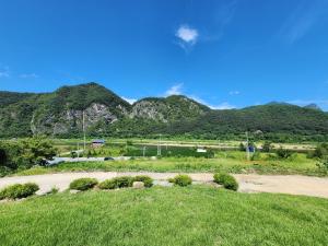 un camino de tierra con una montaña en el fondo en 단양추억펜션, en Paegam
