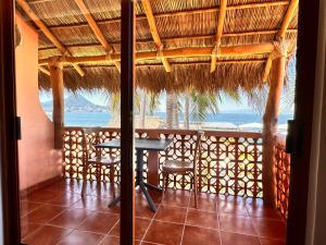 a table and chairs in a room with a view of the ocean at La Posada Hotel Boutique in Manzanillo