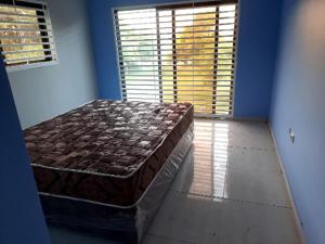 una camera con un letto in una stanza con due finestre di Ponta Family holiday house a Ponta do Ouro