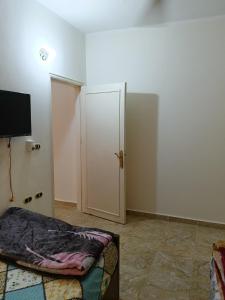 um quarto com uma porta, uma cama e uma televisão em Guest room science em Marsa Alam
