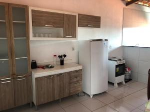 a kitchen with wooden cabinets and a white refrigerator at Recanto da Baía in Baía Formosa